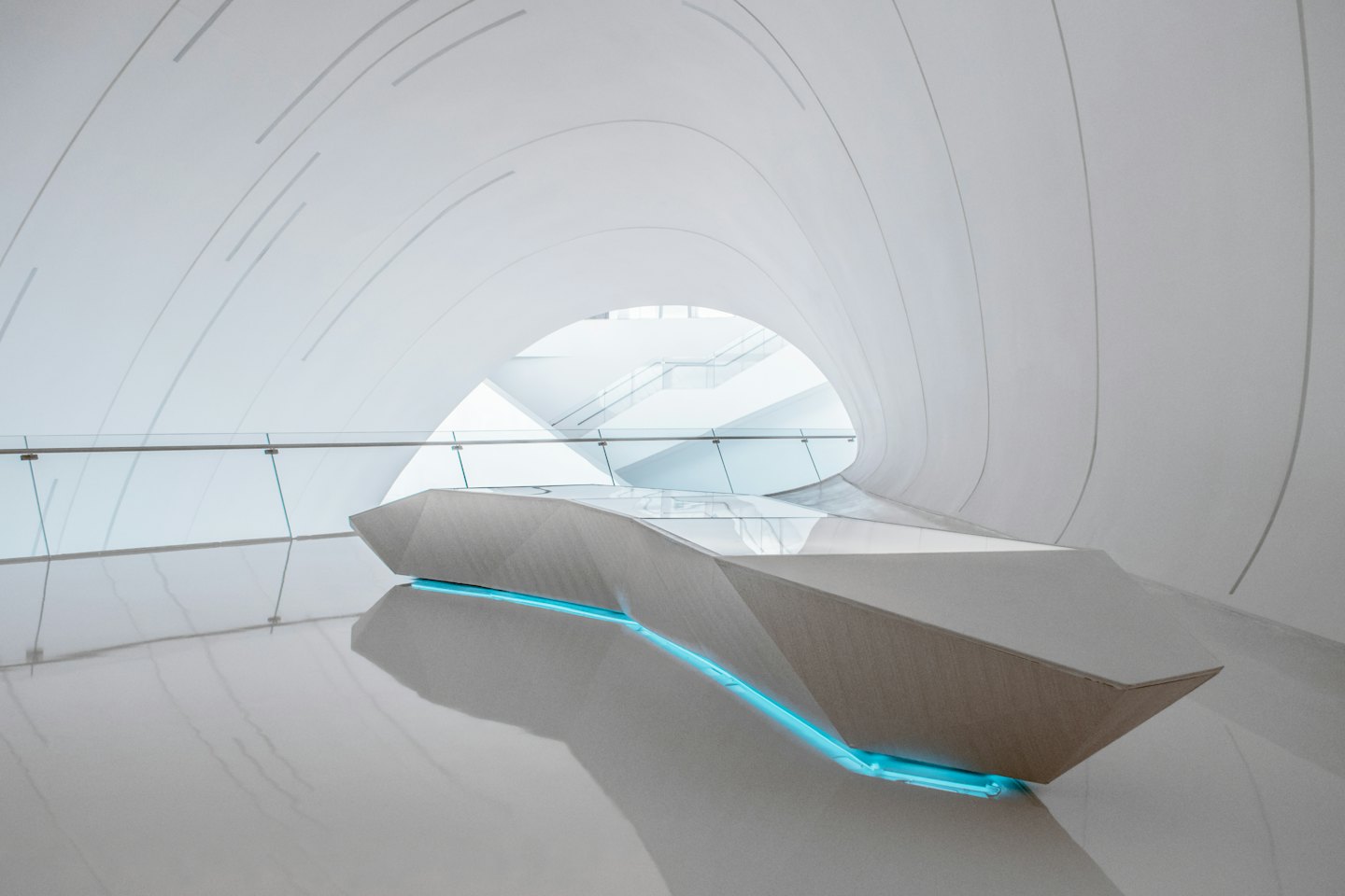 Modern reception desk with blue lights in a white building.